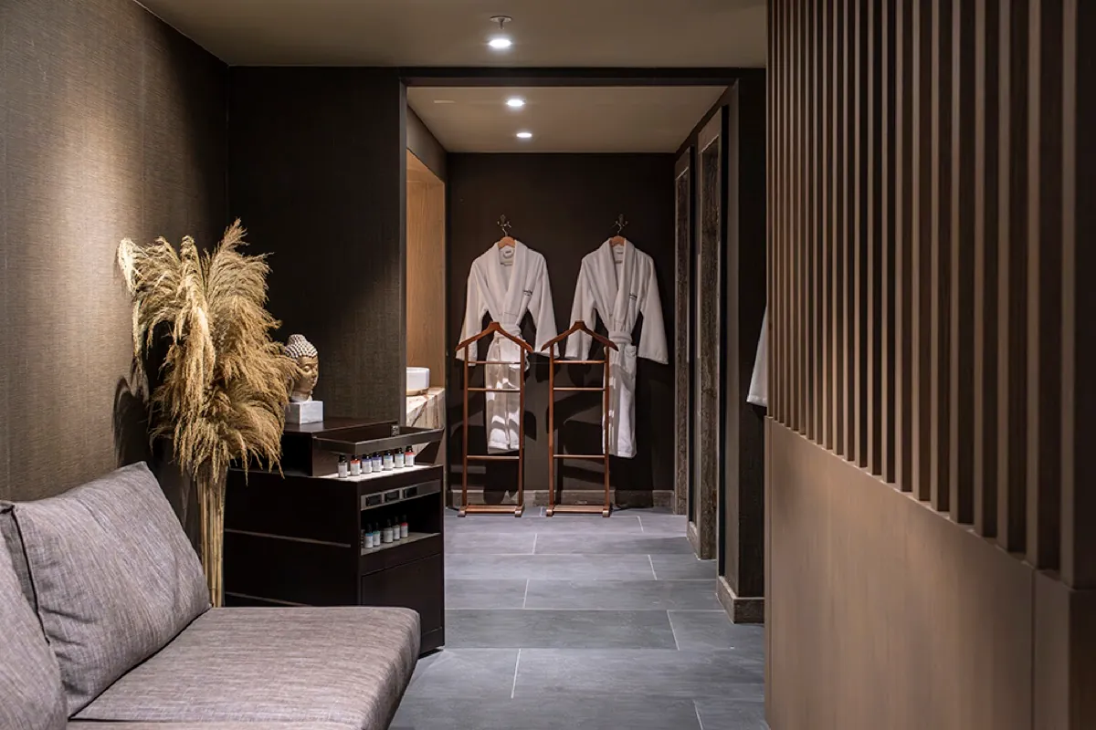 Spa alanında oturma bölümü ve askılarda beyaz bornozlar